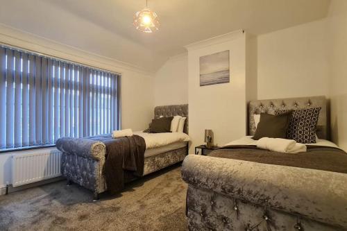 - une chambre avec 2 lits, un canapé et une fenêtre dans l'établissement Saint Johns 3-bedroom House-Greater London, à Dartford