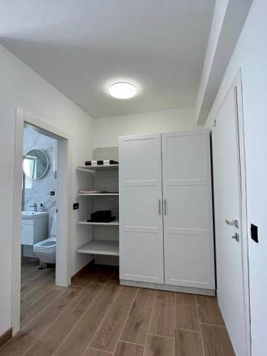 a white bathroom with a toilet and a closet at Harmony suites in Bol