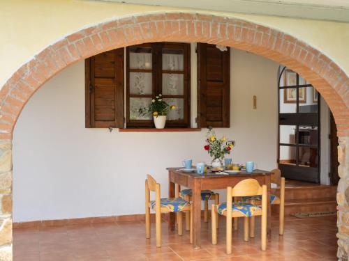 ein Esszimmer mit einem Torbogen, einem Tisch und Stühlen in der Unterkunft Villa Bouganville by Interhome in Bibbona