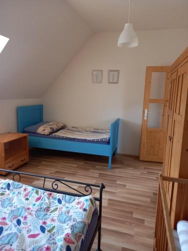 1 dormitorio con 2 camas y suelo de madera en Chalupa U Kravína, en Rtyně v Podkrkonoší