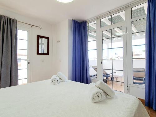 1 dormitorio con 1 cama blanca grande y toallas. en Casa Piscis, en Adeje
