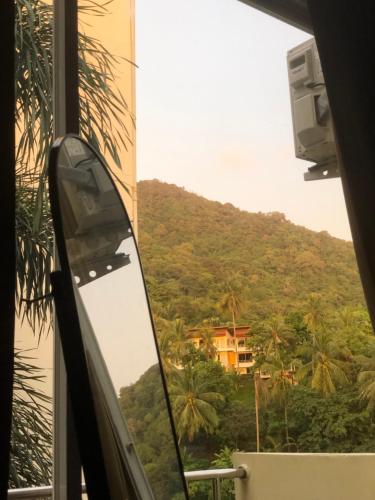 a window with a view of a mountain at TIL DAWN Phuket in Ban Karon