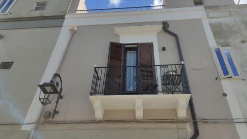 a white building with a balcony and a window at DIMORA STORICA ALLA ROTONDA in Mottola
