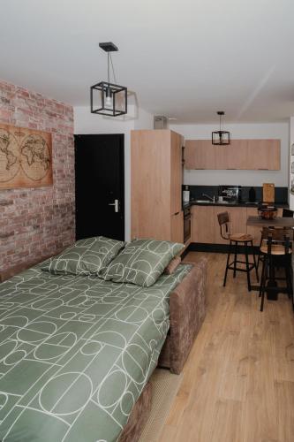 une chambre avec un grand lit et une cuisine dans l'établissement Appartement 2 pièces L'industriel en centre-ville de Cambrai, à Cambrai