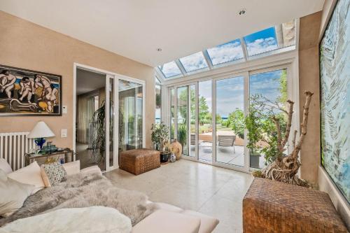 a living room with a couch and a large window at Wellness-Oase mit Wasserblick, Pool, Sauna & Fitnessbereich in Rankwitz