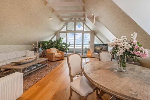 una sala de estar con una mesa con flores. en Wellness-Apartment mit Wasserblick, Pool, Sauna & Fitnessbereich, en Rankwitz