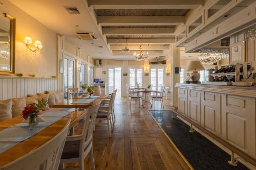 a restaurant with tables and chairs and a bar at Jabłoń Lake Resort in Pisz