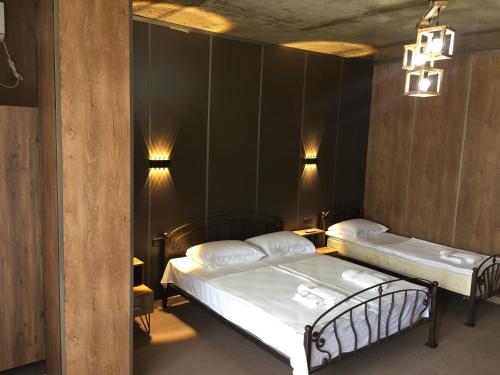 - 2 lits dans une chambre avec des murs et des lumières noirs dans l'établissement Nona's House and Aparts, à Kobuleti