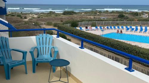 海洋拉卡諾的住宿－BELLE VUE OCEAN, 2 CHAMBRES, terrasse 30m2, parking privatif et piscine en été，一个带两把椅子的阳台和一个游泳池