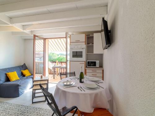 Una sala de estar con una mesa y un sofá azul. en Apartment Les Argentines by Interhome, en Saint-Palais-sur-Mer