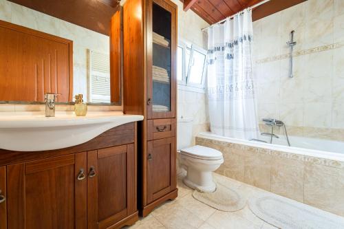 een badkamer met een wastafel, een toilet en een bad bij Mataragkas Villa - 1km from Laganas Center, by ZanteWize in Laganas