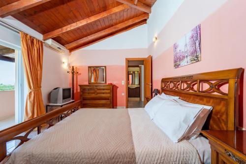 een slaapkamer met een groot bed en een televisie bij Mataragkas Villa - 1km from Laganas Center, by ZanteWize in Laganas