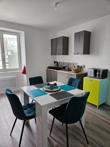 une cuisine avec une table et des chaises dans une pièce dans l'établissement Appartement 4 personnes vue mer à Santec au pied de la plage du Dossen, à Santec