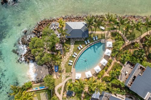 an aerial view of a resort with a swimming pool and the ocean at Mango House Seychelles, LXR Hotels & Resorts in Baie Lazare Mahé