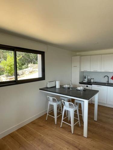 une cuisine avec une table et des chaises dans une pièce dans l'établissement T2 très bien équipé vue mer et au calme, à Ajaccio