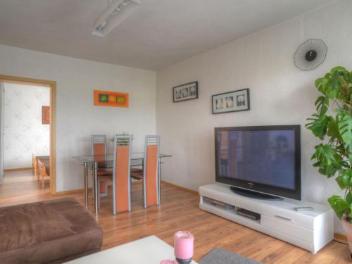 - un salon avec une télévision et une table avec des chaises dans l'établissement Apartment Ella by Interhome, à Bromskirchen