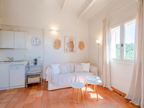 un salon avec un canapé blanc et une table dans l'établissement Apartment Les Hauts des Issambres-14 by Interhome, aux Issambres