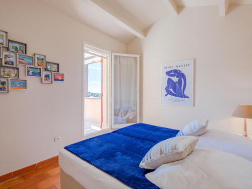 une chambre avec un lit avec des draps bleus et une fenêtre dans l'établissement Apartment Les Hauts des Issambres-14 by Interhome, aux Issambres