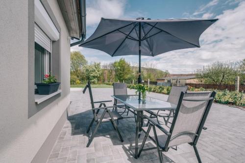 einen Tisch und Stühle mit Sonnenschirm auf einer Terrasse in der Unterkunft Peace Apartments 0 and 4 - Happy Rentals in Badacsonytomaj