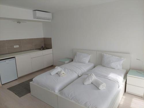 Habitación blanca con 2 camas y toallas en Casa Maria City Apartments en Timisoara