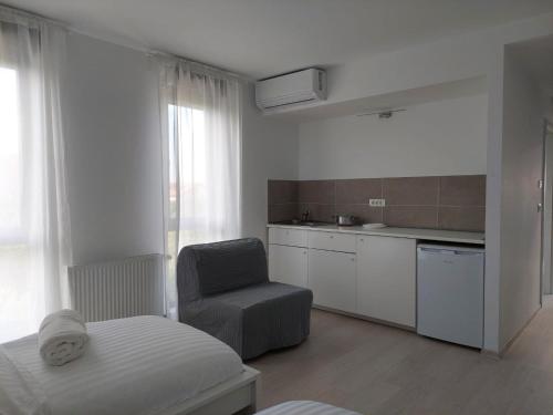 uma cozinha com uma cama e uma cadeira num quarto em Casa Maria City Apartments em Timişoara