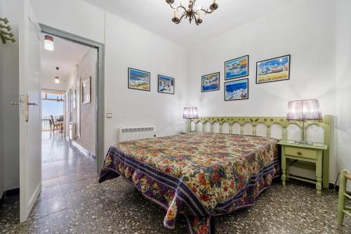 ein Schlafzimmer mit einem Bett und einem Tisch mit einer Lampe in der Unterkunft Edificio Victoria 5º-7ª in La Playa