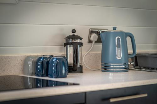 eine Küchentheke mit einer Kaffeekanne und einem Wasserkocher in der Unterkunft Glamping Pod Two - Holly Tree Barns in Halesworth