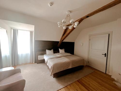 1 dormitorio con cama y lámpara de araña en Rezidence Wannas Self Check in en Sigulda