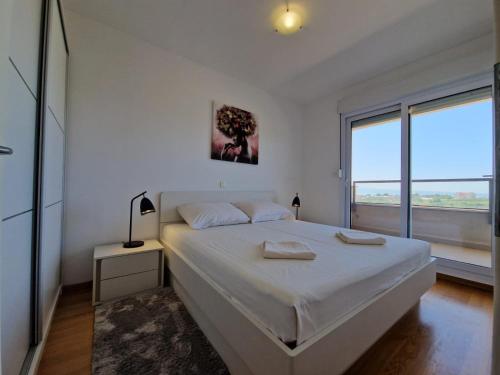 een witte slaapkamer met een bed met twee handdoeken erop bij Luxury Penthouse "MANK" with private Parking in Split