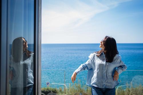 two women looking out a window at the ocean at Hotel Calanca in Marina di Camerota