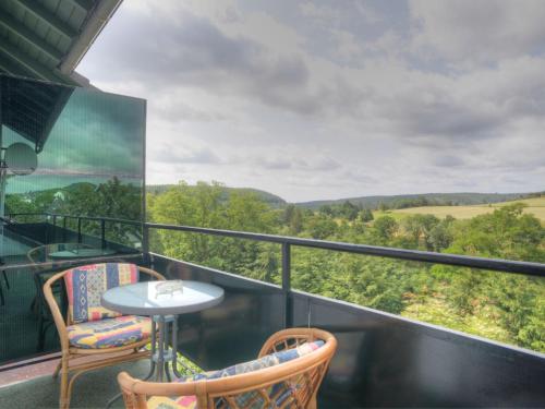 balcón con mesa, sillas y vistas en Holiday Home Möllmann by Interhome en Bromskirchen