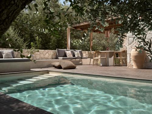 a swimming pool with a couch and a table at Zayn Luxury Villas, a Serene Escape, By ThinkVilla in Zakynthos Town