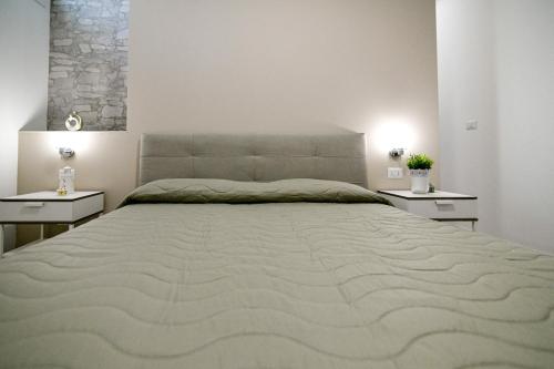 een slaapkamer met een groot bed met 2 nachtkastjes bij Apartment Laura in Avola