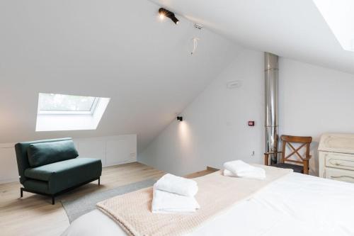 - une chambre avec un lit et une chaise verte dans l'établissement Arbre Epine, à Sart-lez-Spa