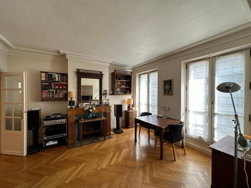 ein Wohnzimmer mit einem Holztisch und einem Esszimmer in der Unterkunft 70 sqm apartment in 75008 Paris in Paris