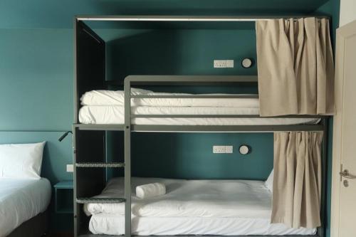 three bunk beds in a room with a bed at Heyday Hostel Ballina in Ballina