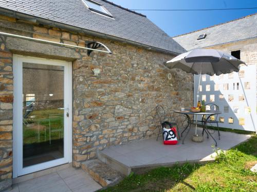 a table with an umbrella next to a stone building at Holiday Home La petite Iroise by Interhome in Plogoff