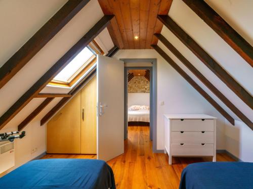 a attic room with two beds and a bedroom at Holiday Home La petite Iroise by Interhome in Plogoff