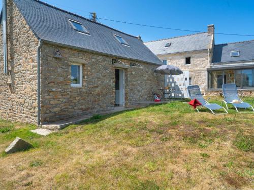 two chairs sitting on a lawn in front of a house at Holiday Home La petite Iroise by Interhome in Plogoff