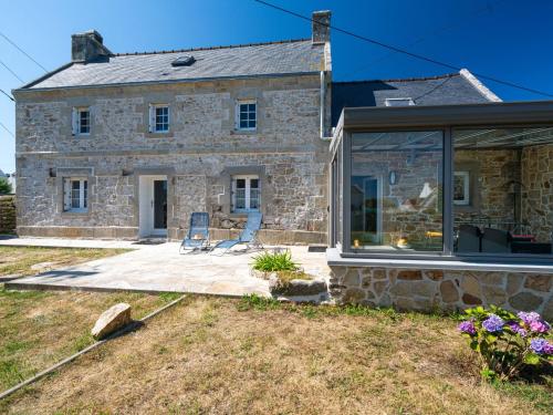 kamienny dom z 2 krzesłami na patio w obiekcie Holiday Home L'Iroise by Interhome w mieście Plogoff