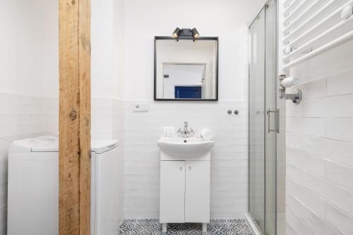 a white bathroom with a sink and a mirror at Katowice Centrum Studio Styczyńskiego by Renters in Katowice