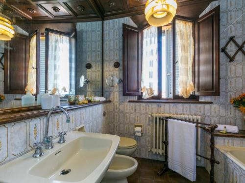 a bathroom with a sink and a toilet and windows at Villa Il Belvedere by Interhome in Lari