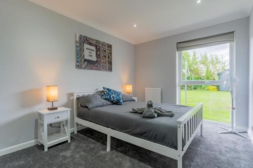 a white bedroom with a bed and a window at Jodi's Bungalow - Garden and Parking in Nottingham