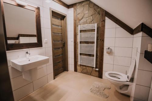 a bathroom with a sink and a toilet at Nestville Apartments in Hniezdne