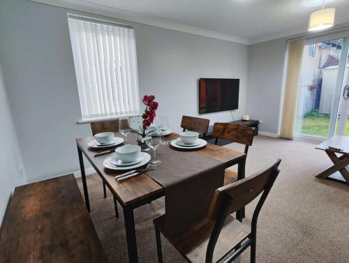 a dining room with a table and chairs and a television at Harmony in Bicester in Bicester