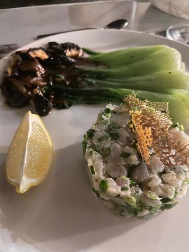 a plate of food with broccoli and a lemon at Cosy Guest House Sous le Badamier in Grand Baie