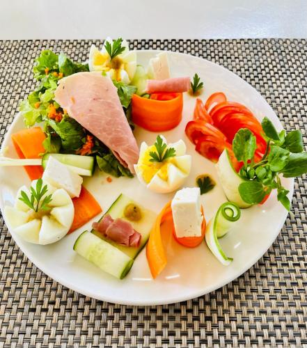 a white plate of food with vegetables and meat at Cosy Guest House Sous le Badamier in Grand Baie