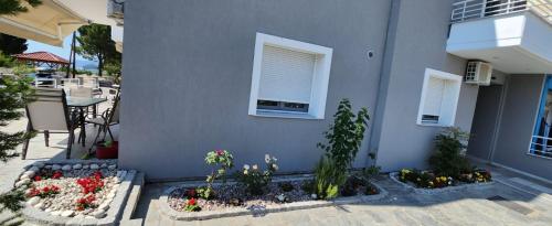 a gray building with some flowers and a window at SeaSide II family appartment in Keramotí
