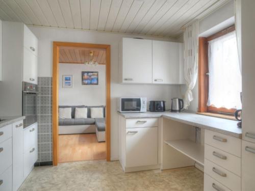 een keuken met witte kasten en een woonkamer bij Holiday Home Peppa by Interhome in Medebach