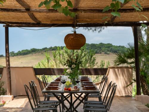 une table avec des chaises assises sous un toit en bois dans l'établissement Villa La Veduta by Interhome, à Grosseto
